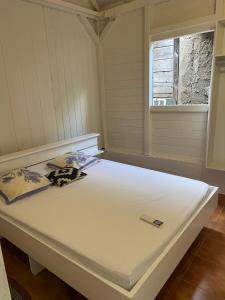 a large white bed in a room with a window at Séjour Caraïbe in Pointe-Noire