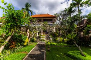 a house with a garden in front of it at Villa Mandi Resort & spa in Ubud