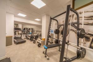 a gym with several treadmills and machines at Hotel Principe Wellness&Spa in Playa de Palma