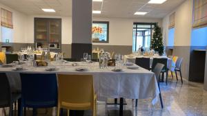 a dining room with tables and chairs and a christmas tree at Moderno Albergo Didattico in San Pellegrino Terme