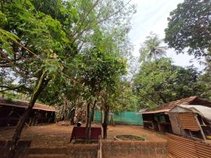 a person sitting on a bench in a village at Haris Farm House in Kannur +4 photos