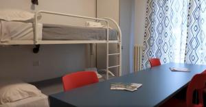 a room with a table and a bunk bed at Moderno Albergo Didattico in San Pellegrino Terme