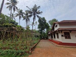 a house with palm trees in the background at Haris Farm House in Kannur