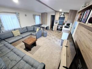 a living room with a blue couch and a table at Birchington Vale - Trieste Sleeps 6 in Westgate-on-Sea