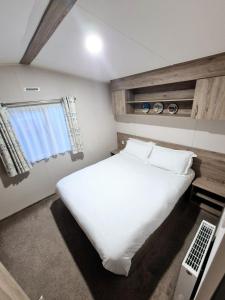a bedroom with a large white bed and a window at Birchington Vale - Trieste Sleeps 6 in Westgate-on-Sea