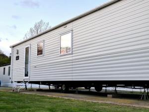 a large silver trailer is parked in a driveway at Birchington Vale - Trieste Sleeps 6 in Westgate-on-Sea