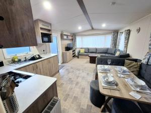 a kitchen and living room with a table in a caravan at Birchington Vale - Trieste Sleeps 6 in Westgate-on-Sea