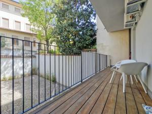 a balcony with a white chair on a wooden deck at Private Terrace Cozy Flat near Vicenza Center in Vicenza