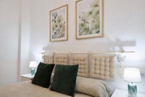 a bedroom with a bed with two pictures on the wall at Arenas del Coliseo Centro Parking Gratis in Mérida