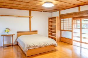 a bedroom with a bed and a book shelf at Mountain Home - One Hour From Osaka in Uda