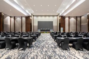 a conference room with chairs and a projection screen at Grand Swiss-Belhotel Darmo in Surabaya +30 photos