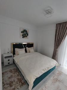 a bedroom with a large bed with white sheets at Panorama Loft in Gura Humorului