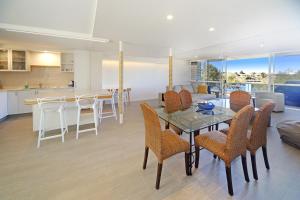 a kitchen and living room with a table and chairs at Portsea in Mooloolaba
