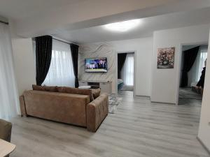 a living room with a couch and a flat screen tv at Panorama Loft in Gura Humorului