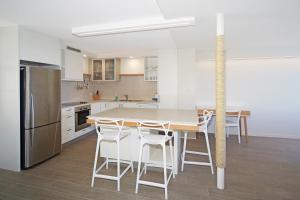 a kitchen with a table and chairs and a refrigerator at Portsea in Mooloolaba