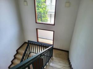 a staircase with two windows in a white room at Casa Palma by Ezzego in Bandung