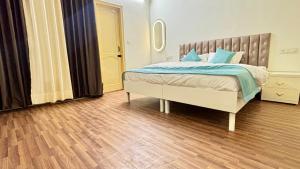 a bedroom with a bed with blue pillows on it at Hotel Divine in Faridabad +5 photos