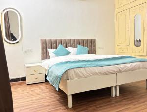 a bedroom with a large bed with blue pillows at Hotel Divine in Faridabad