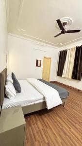 a bedroom with a bed and a ceiling fan at Hotel Divine in Faridabad