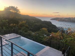 a swimming pool on a balcony with a view of the ocean at Casa Elio - Bed and Breakfast in San Juan del Sur
