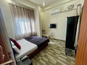 a small bedroom with a bed and a window at Hotel Pilgrrim in Varanasi