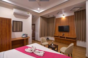 a hotel room with a bed and a tv at The Parmatma Hotel in Udaipur