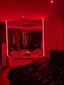 a red room with a tub with a mirror at Shiny Cloud Love Room in Limoux