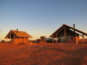 a couple of buildings in the middle of a field at Tented Camp in Augrabies in Kakamas