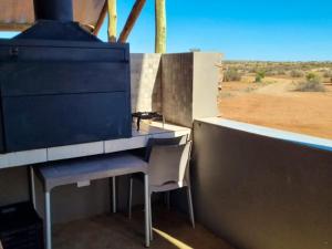 a desk and a chair sitting next to a wall at Tented Camp in Augrabies in Kakamas +2 photos