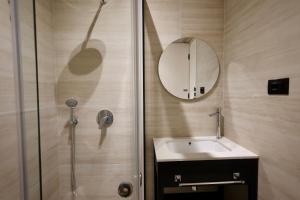 a bathroom with a shower and a sink and a mirror at Hotel Tutti in Durrës