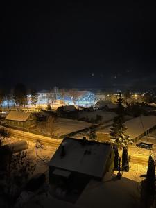a night view of a city with snow and lights at Ludza Comfort Apartment in Ludza