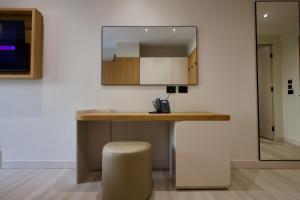 a kitchen with a counter with a stool and a mirror at Hotel Tutti in Durrës +26 photos