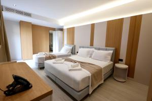 a hotel room with two beds and a table at Hotel Tutti in Durrës