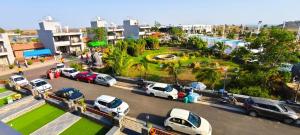 a parking lot with cars parked in front of a park at Shriji Ananda Hotel & Resort in Dhār