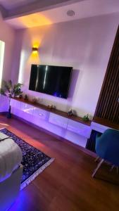 a living room with a large flat screen tv on a wall at Caelume Luxury Studios in Ghaziabad