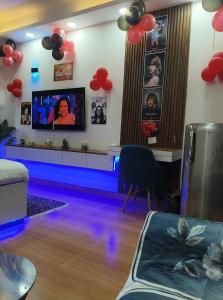 a living room with a tv and balloons on the wall at Caelume Luxury Studios in Ghaziabad