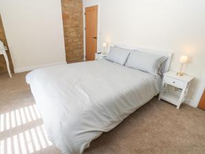 a white bed in a room with two night stands at 2 Low Road in Bishop Auckland