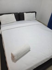 a large white bed with a towel on it at N24 Confy apartment in Luanda
