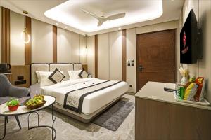 a bedroom with a bed and a table and a tv at Hotel Stay Well Dx in New Delhi