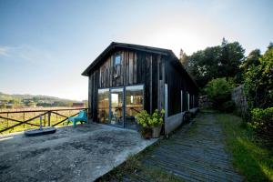 a small black house with glass doors on a patio at Casa de Cabanelas in Bustelo