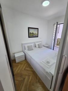 a bedroom with a large white bed with a window at Luxury flat Boka Nest in Dobrota