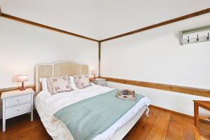 a bedroom with a bed and a wooden floor at Acorn Barn in Ashford