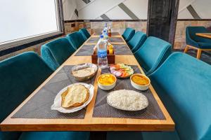 a long table with plates of food and bottles of water at Hotel Stay Well Dx in New Delhi +38 photos