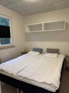 a large white bed in a room with a window at Rødhus Camping in Pandrup