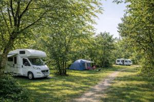 a white van parked in a field next to a tent at Rødhus Camping in Pandrup +5 photos