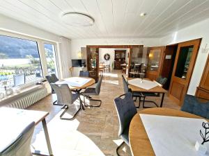 a restaurant with tables and chairs and a large window at Pension Mosella, Gästezimmer in Sankt Aldegund