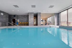 a large swimming pool with blue water in a building at Quarto Verde in Bergamo