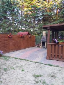 a backyard with a wooden fence and a gazebo at Domek nad jeziorem in Jagodne