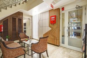 a room with chairs and a table and a refrigerator at Hotel Stay Well Dx in New Delhi