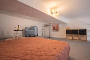 a bedroom with a large bed and a chair at La vie en rose in Grasse